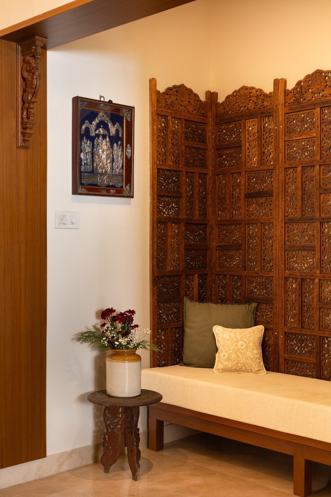 Entrance daybed framed by a hand-carved wooden screen
