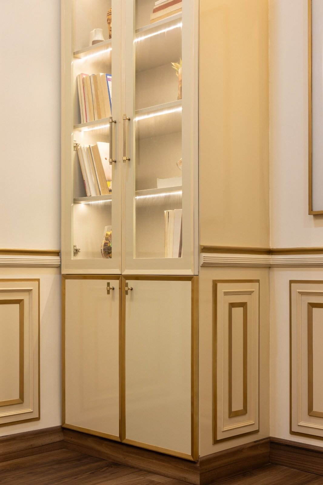 Built-in home library shelving finished in cream and gold