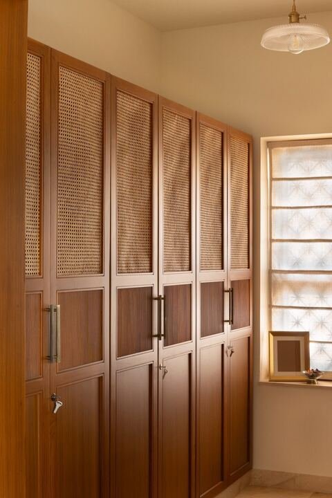 Wardrobe wall finished with woven mesh panel doors