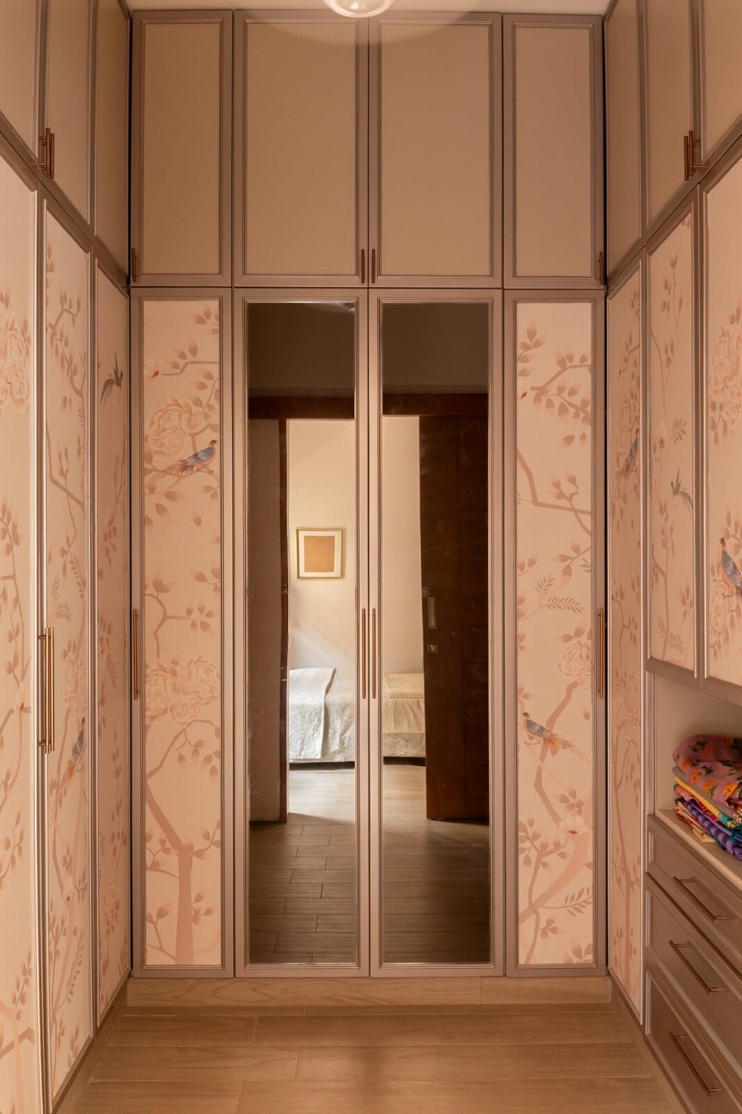 Hallway finished with patterned wallpaper and a mirrored doorway